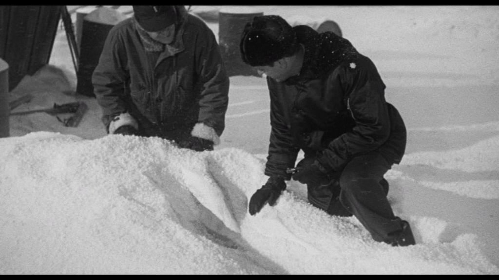 Die Militärs knien vor der großen Spur im Schnee